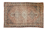 Faded blush, charcoal, and beige triple medallion design on a distressed vintage Shiraz rug 5'2