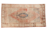 Distressed vintage Oushak runner featuring a dusty rose medallion, faded indigo blue, and neutral beige tones.