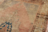 Distressed Oushak rug detail: stepped geometric patterns, low pile, dusty rose and faded indigo.