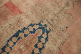 Low pile texture and faded indigo, dusty rose pattern detail of distressed Oushak rug.