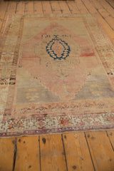Distressed Oushak rug runner's patterned border with low pile texture, dusty rose, and faded indigo.