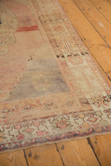 Vintage Oushak rug edge with distressed dusty rose, ivory, muted blue low pile and geometric patterns.