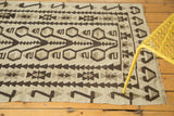 Geometric stylized patterns in charcoal, silver, and antique ivory kilim with fringe.