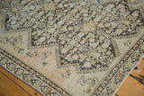 Distressed hand knotted antique Malayer rug corner with visible wear, ivory and deep brown border.