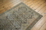 Distressed corner of an antique Malayer rug, displaying lattice henna motifs and visible foundation wear.