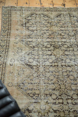 Antique Malayer rug's distressed pile in ivory and beige, with faded henna plant motif.