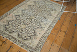 Distressed Malayer rug showing aged texture, visible foundation, and intricate henna plant motif.
