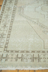 Distressed vintage Oushak rug, showing even wear across knot heads and neutral geometric border.