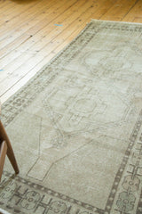 Distressed vintage Oushak rug runner showing minimalist geometric medallion in neutral tones.
