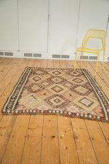 Colorful fringed edge of vintage Turkish Kilim rug, showing diamond motifs.