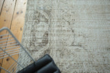 Distressed vintage Oushak carpet with faded ornate pattern and exposed foundation.