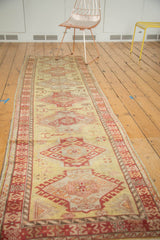 Vintage Turkish Oushak runner with a central column of red medallions on a gold field.