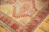 Even, low pile and hand-knotted texture on a vintage Oushak rug in dusty gold and red.