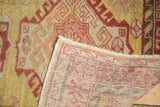 The folded corner of a vintage Oushak runner reveals its hand-knotted weave and low wool pile.