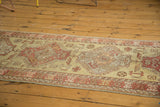 Long view of a vintage Oushak runner showing repeating medallions and serrated leaf motifs.