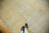 Distressed texture of antique Oushak carpet, highlighting worn pile and faded ivory, sand, and pale gold hues.