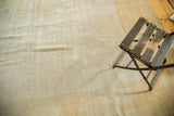 Textured field of distressed antique Oushak rug with faded ivory and sand hues.