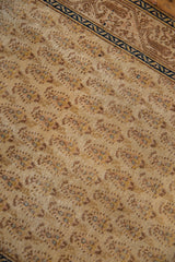 Low pile beige field of vintage Tabriz rug with repeating Mir cyprus tree motifs.