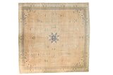 Distressed antique Chinese square carpet: beige field, cobalt blue roundel, and meandering borders.