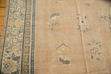 Distressed antique Chinese carpet shows its geometric running T border and scattered field motifs.