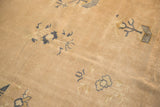 Scattered cobalt blue plant motifs on a pale beige field, highlighting the carpet's aged patina.