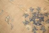 Distressed cobalt blue roundel medallion with pictorial details on a pale mauve Chinese rug.