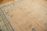 Distressed pale mauve field, cobalt blue 'running T' border, and scattered Chinese motifs.