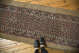 A perspective view of an antique Serab runner's intricate trellis pattern and wide camel hair border.