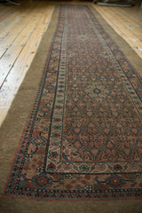 A long perspective view of an antique Serab runner showing its repeating allover lattice design and camel hair field.