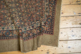 The wide, natural camel hair border and detailed geometric field of a draped antique Serab runner rug.