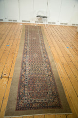 Angled view of an antique Serab runner with a wide camel hair border and intricate lattice field.