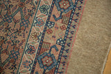 The antique Serab runner's intricate geometric border alongside its tightly woven camel hair field.