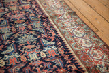 Malayer runner's meandering border in ivory, blue, and madder red alongside the navy field.