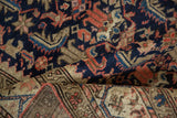 Vintage Malayer rug fold: dense navy field with serrated Herati pattern and beige border.