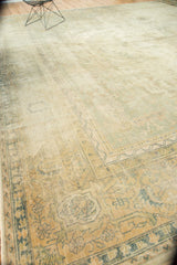 Corner of distressed Sparta carpet, revealing worn texture, pale sage, gold, and floral motifs.