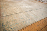 Distressed texture of vintage Sivas carpet, with faded pale bronze, ivory, and aqua tones.