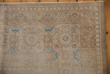 Distressed pale bronze and ivory Sivas carpet texture with faded blue Veramin motifs.