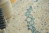 Bold blue curvilinear patterns on a distressed vintage Persian Meshed rug.