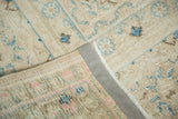 Distressed vintage Meshed carpet detail, showing worn pile, blue motifs, and secured side.