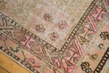 Vintage distressed Khotan runner corner: blush pink geometric border, even wear to knot heads.