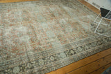 Charcoal and pale sage floral border on distressed Mahal carpet, showing wear.