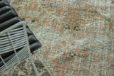 Worn knot heads and distressed texture of the Mahal carpet, blending terra cotta and pale sage.