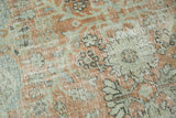 Textured detail of distressed Mahal carpet, featuring even wear and terra cotta, pale sage, and silver tones.