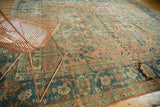 Antique Persian Lilihan rug with distressed blush field and ornate teal border.