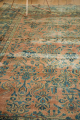 Distressed texture of antique Lilihan carpet, faded blush, teal, and gold botanicals.