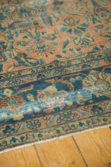 Close-up of distressed antique Lilihan rug with blush field, teal border, and foundation etching.