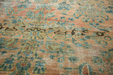 Distressed texture of antique Lilihan rug showing etching and botanical patterns in blush, teal, gold.
