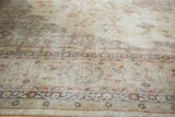 Distressed vintage Sparta rug showing faded ivory, pale rose, and charcoal floral vinery.