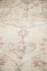 Distressed vintage Sparta rug showing even wear, ivory pile, and pale rose palmette motifs.