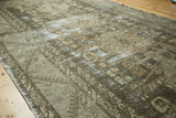 Distressed texture highlights faded geometric floral patterns in charcoal, gray, and beige.